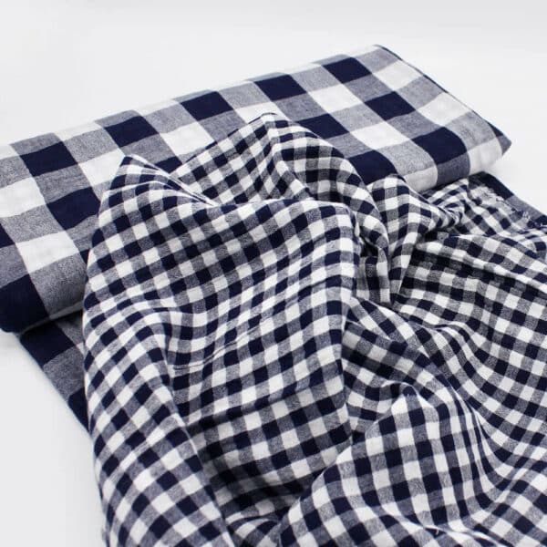 Bolt of navy gingham double gauze showing both sides of the fabtic