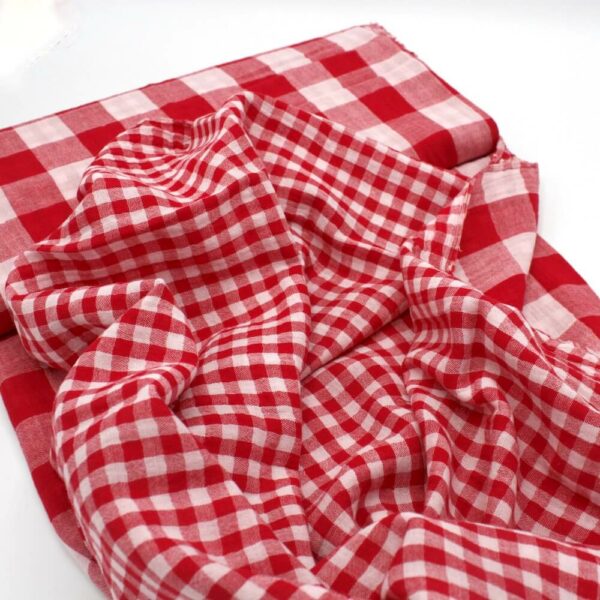 bolt of red gingham double gauze fabric showing both sides