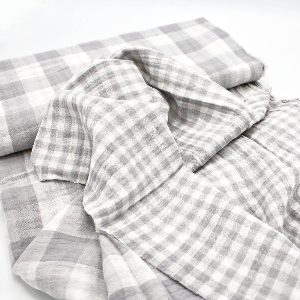 bolt of grey and white gingham double gauze showing both sides of fabric.