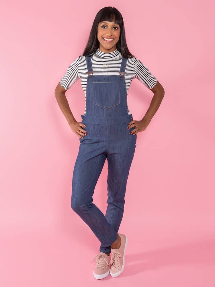 young woman wearing a pair of slim denim dungarees over a striped short sleeved t-shirt