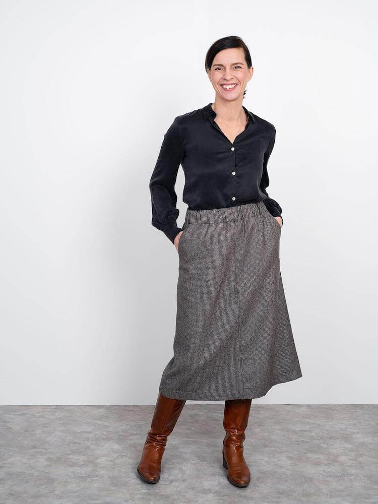 lady wearing an A line skirt with elastic waistband and black long sleeve shirt