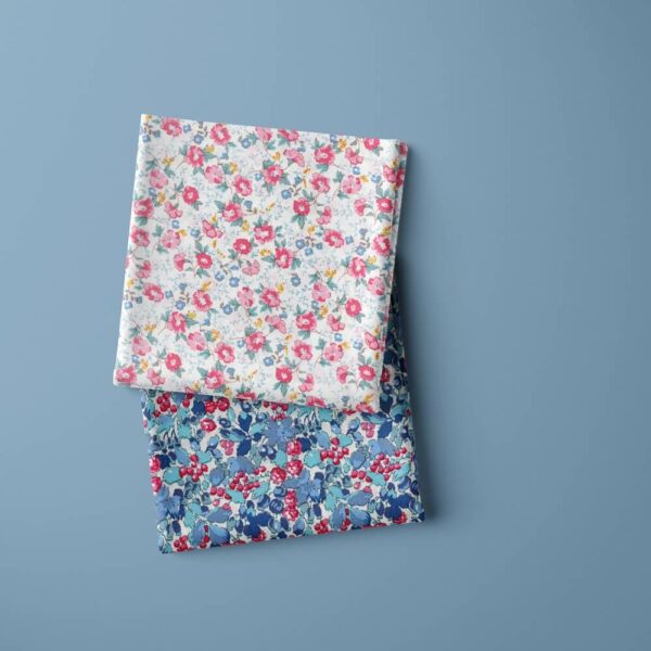 folded metres of cotton poplin floral on a blue ground