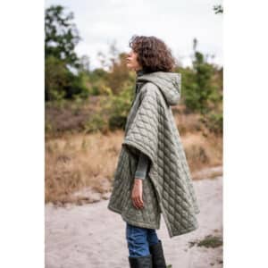 lady standing side on wearing a green quilted coat cape