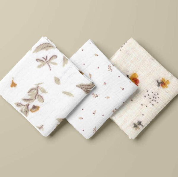 folded squres of gold floral on white double gauze