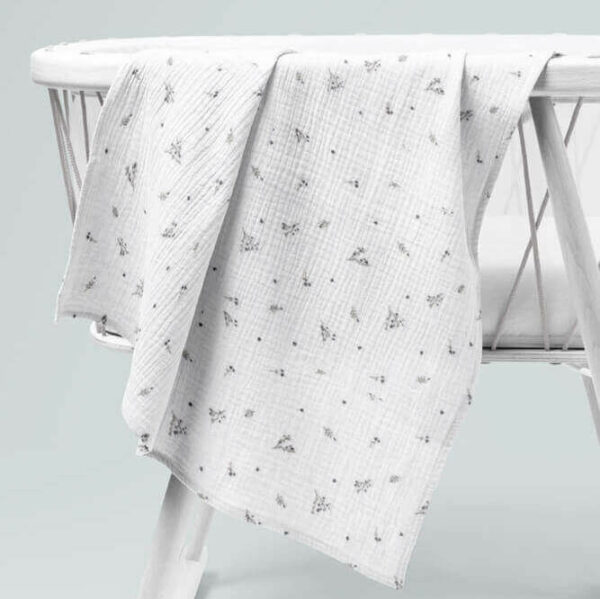 double gauze blanket in dillen grey draped over a child cot