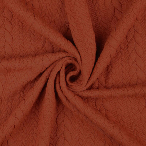 Orange cable knit jersey fabric in a swirl