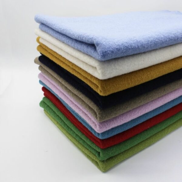 selection of our boiled wool plain fabrics in a pile