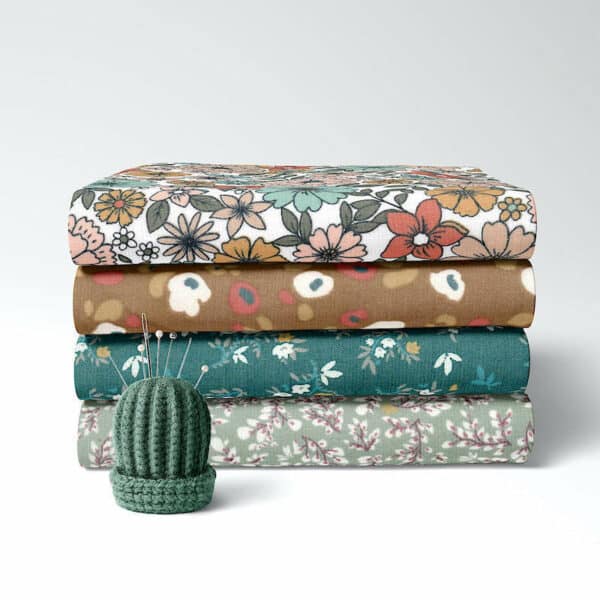 Stack of coordinating pretty printed cotton babycord fabrics Image1a