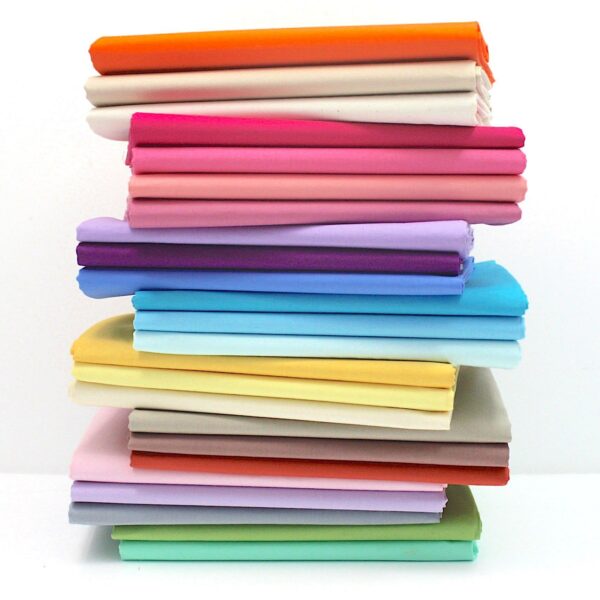 Pile of folded devon cotton fabric in range of colours