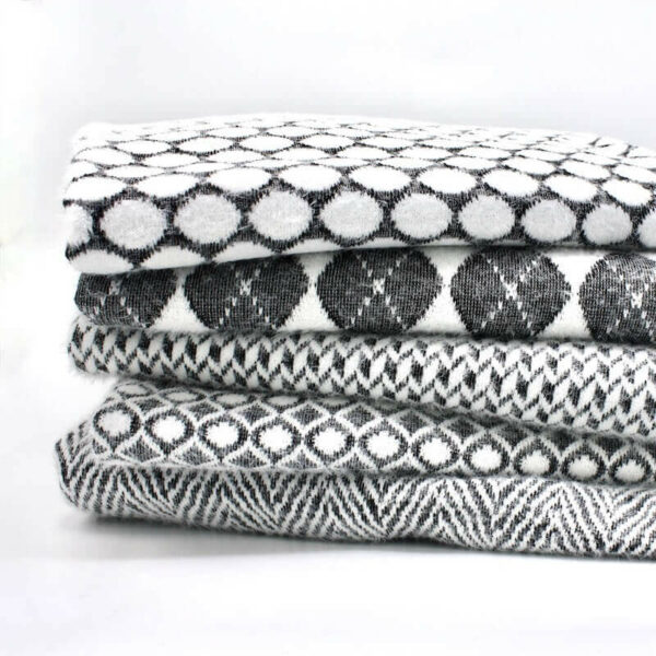 Side on view of folded bundle of black and white jersey fabric