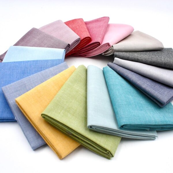 16 x folded chambray cotton fabric displayed in a circle in lots of colours
